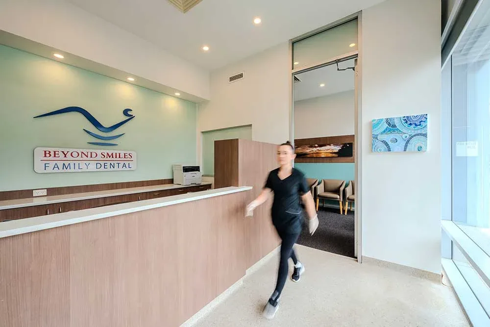 Reception at Beyond Smiles Family Dental, Norwest Business Park &mdash; the practice's blue-wave signage above the timber counter